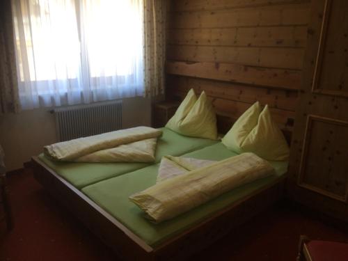 Bett mit Kissen darauf in einem Zimmer in der Unterkunft Tirolerheim Grüner in Sölden