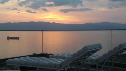 a group of chairs sitting next to a body of water at Mavi Panorama Villa in Cesme