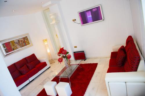 a living room with two red couches and a table at Hotel Fernando IV in Martos