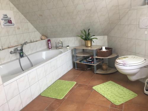 uma casa de banho com uma banheira branca e um WC. em FeWo s Runde Wiese RW em Greifswald