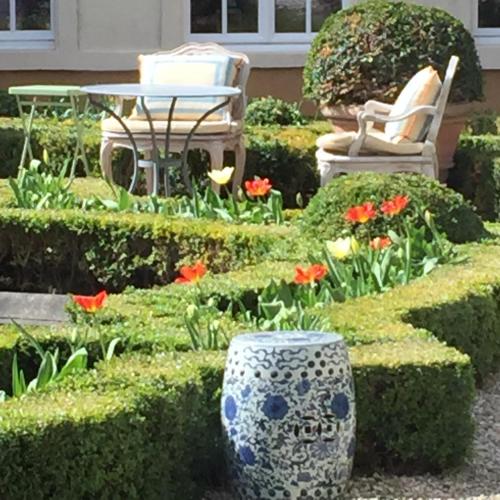 a garden with a table and chairs and flowers at B&B The Verhaegen in Ghent