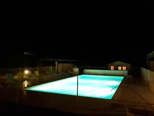 a swimming pool lit up at night at Logis Hotel des Granges in Arles