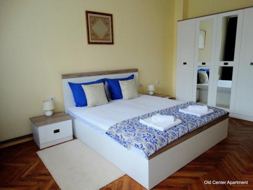 a bedroom with a large bed with blue pillows at Old Center Apartment in Ruse