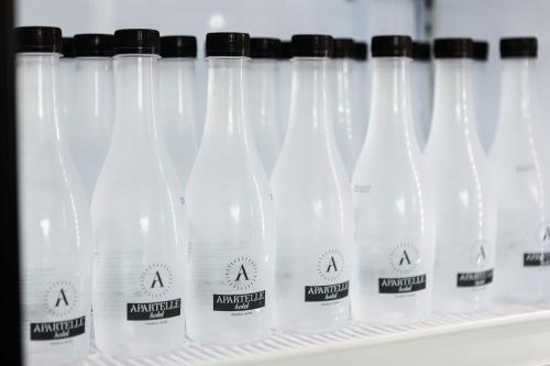 a row of plastic bottles on a shelf at Apartelle Jatujak Hotel in Bangkok