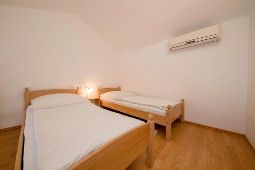 a room with two beds in a room with a radiator at Apartments Dedić in Supetarska Draga