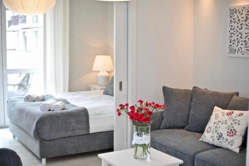 a living room with a bed and a couch at Apartamenty Porto Eli in Rowy