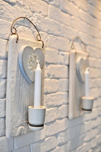 a wall with three candles on a brick wall at Apartamenty Porto Eli in Rowy