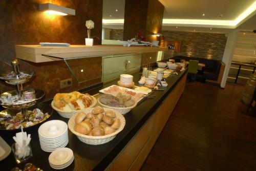 a buffet line with bowls of food in a restaurant at Hotel Astoria in Ulrichen