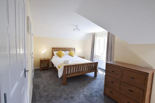 a bedroom with a bed and a dresser and a window at Hillyard Mews in Newcastle