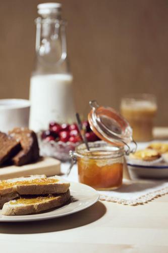 une table avec une assiette de pain et un pot de miel dans l'établissement Original Douro Hotel, à Peso da Régua