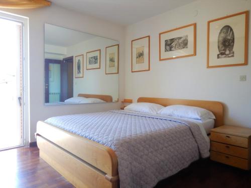 a bedroom with a large bed and a mirror at PANORAMIC apartment in Bardolino