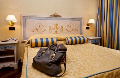 a hotel room with a large bed with a purse on it at Punta Campanella Resort & Spa in Massa Lubrense
