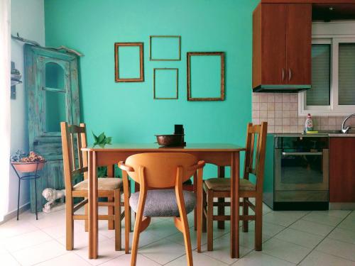 a kitchen with a wooden table and chairs in a room at Dimitris Luxury Apartment in Keramoti