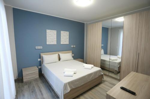 a blue bedroom with a bed and a mirror at SIROIKIA luxury apartments in Siracusa