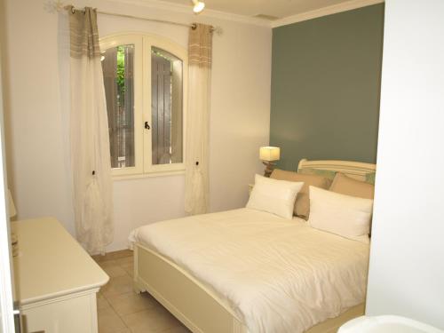 Schlafzimmer mit einem Bett mit weißer Bettwäsche und einem Fenster in der Unterkunft Villa Fleurie in Les Angles Gard