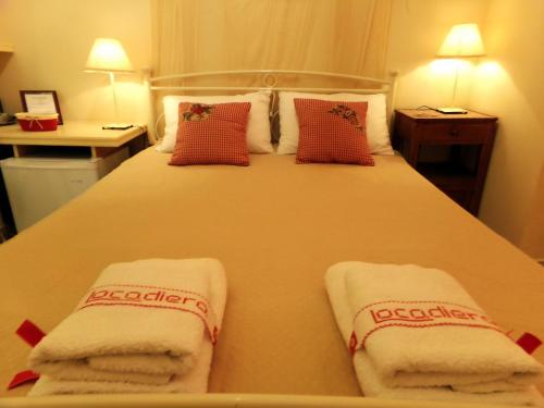 A bed or beds in a room at Locadiera Pansion