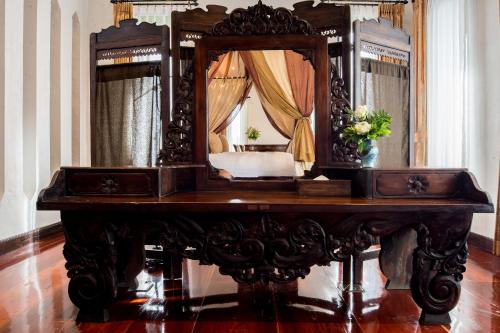 a dressing table with a mirror on top of it at Shinnabhura Historic Boutique Hotel in Phitsanulok
