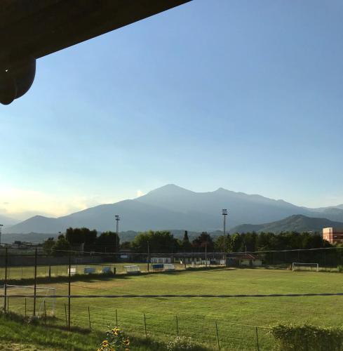 a view of a soccer field with mountains in the background at Castel Apartment in Castellamonte