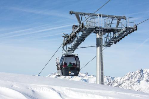 a ski lift with people on it in the snow at Hotel Alpenkönigin - ALPINE LUXURY in See