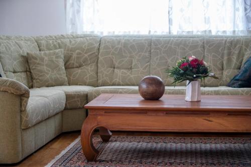 a living room with a couch and a table with a vase of flowers at Apartments Dedić in Supetarska Draga