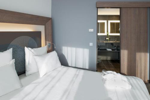 a bedroom with a large bed with white pillows at Novotel Hannover in Hannover