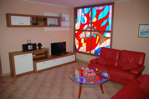 - un salon avec un canapé rouge et un vitrail dans l'établissement Apartments Valbandon, à Fažana