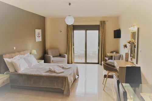 a hotel room with a bed and a desk and a room at Phaedra Suites in Lixouri