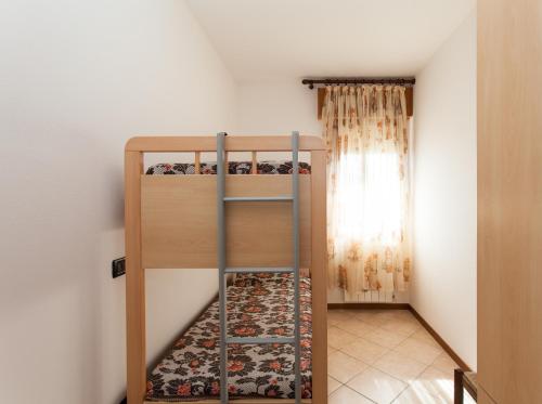 a bunk bed with a ladder in a room at Camping Klaus in Cavallino-Treporti