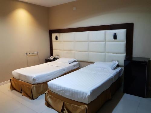 Postel nebo postele na pokoji v ubytování Nuzul Altoot Serviced Apartments