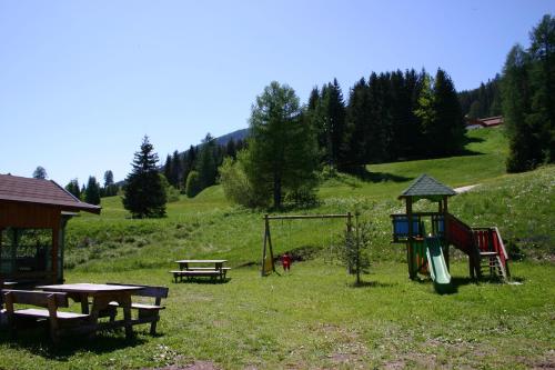 a park with a picnic table and a playground at Garnì Aurora Bed and Breakfast in Soraga