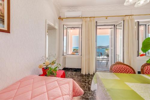 1 dormitorio con cama, mesa y balcón en Veranda Syros House, en Ermoupoli