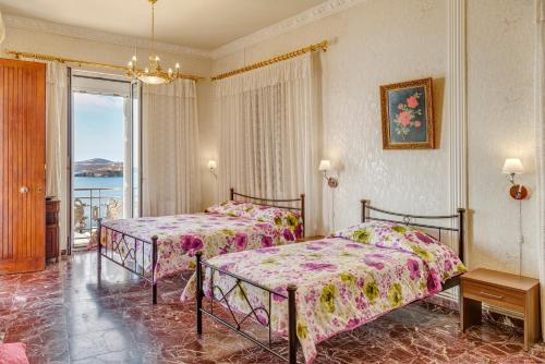 a hotel room with two beds and a balcony at Veranda Syros House in Ermoupoli