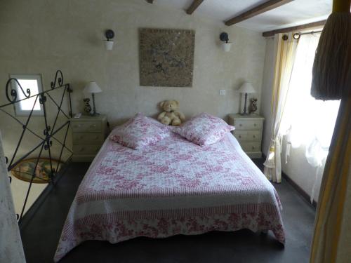 - une chambre dotée d'un lit rose avec un ours en peluche dans l'établissement Les Anges, à LʼIsle-sur-la-Sorgue
