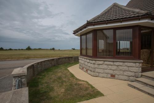 a building with a fence next to a field at GOLFVIEW 4 in Buckie