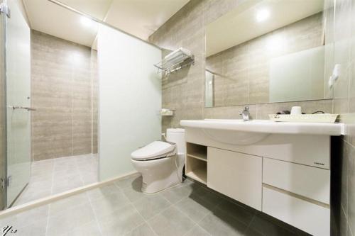 a bathroom with a toilet and a sink and a shower at Xin Ju in Taitung City
