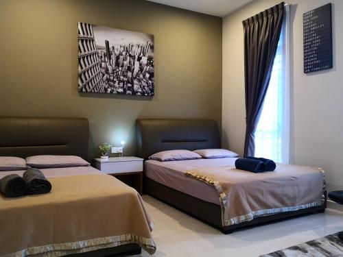 a bedroom with two beds and a window at Laman Kurnia Holiday House in Kota Bharu