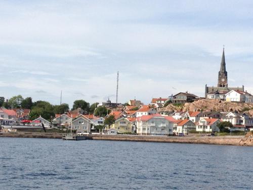 a city from the water with houses and a church at Strandvillan Hotell och Bed & Breakfast in Lysekil