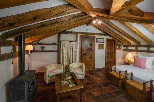 a bedroom with a bed and a wood stove at Posada Real Mingaseda in Navafría