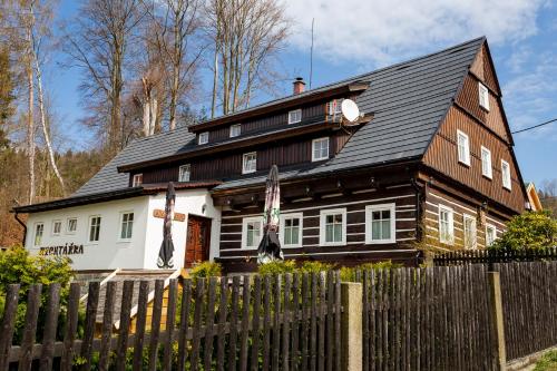 una casa de madera con una valla delante en Chata Rychtářka, en Janov nad Nisou