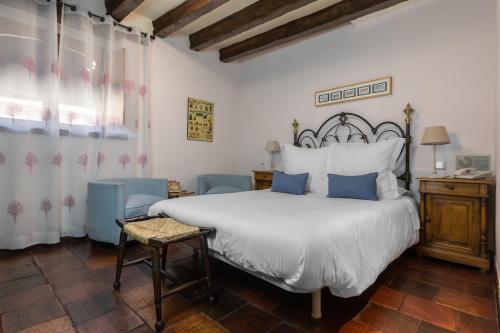 1 dormitorio con 1 cama blanca grande con almohadas azules en Posada Real Mingaseda, en Navafría