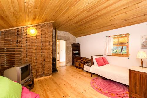 ein Wohnzimmer mit einem Sofa und einem TV in der Unterkunft Casa Sardão in Trofa