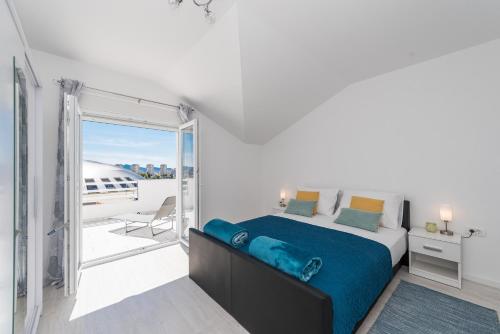a bedroom with a large bed and a balcony at Apartments HIPERION in Zadar