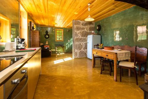 a kitchen with a table and a refrigerator at Casa Sardão in Trofa