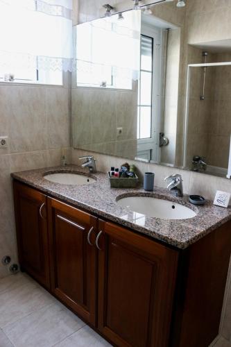 a bathroom with two sinks and a large mirror at Casa da Tia Adília (AL) in Ponta Delgada