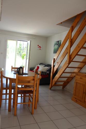 une salle à manger avec une table et un escalier dans l'établissement Maison Saint Hilaire de Riez, 300m de la plage, à Saint-Hilaire-de-Riez