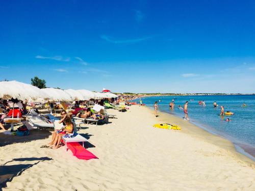 a group of people sitting on a beach at Villa Lido Silvana Marina di Pulsano in Pulsano