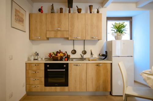 a kitchen with wooden cabinets and a white refrigerator at Casa Nonna Pia in Tirano