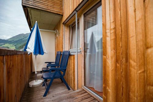 a pair of chairs on a porch with an umbrella at Haus Sonnseite in Au im Bregenzerwald
