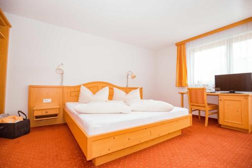 a bedroom with a bed and a desk with a computer at Haus Sonnseite in Au im Bregenzerwald