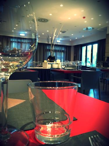 a wine glass sitting on a table in a restaurant at Hotel Forum in Baranzate